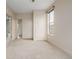 Neutral carpeted bedroom with closet, bright lighting, and one large window at 1848 W 68Th Ave, Denver, CO 80221