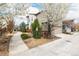 Charming two-story home with attached garage and blooming trees along the walkway at 1848 W 68Th Ave, Denver, CO 80221