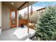 Cozy front porch with orange door, green landscaping and covered entry at 1848 W 68Th Ave, Denver, CO 80221