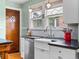 Charming kitchen features white cabinets, marble backsplash, and a farmhouse sink at 2215 N York St, Denver, CO 80205