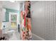 Bathroom with floral shower curtain and hexagon tile at 1111 E Dartmouth Ave, Englewood, CO 80113