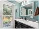 Updated bathroom with a teal vanity and gray tile at 1111 E Dartmouth Ave, Englewood, CO 80113