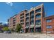Brick building exterior with multiple balconies and street-level retail at 2245 Blake St # L M N, Denver, CO 80205