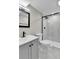 This bathroom boasts white tile and a black-framed shower and mirror with stylish fixtures at 10431 Holland St, Broomfield, CO 80021