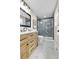 Modern bathroom boasts tiled walk-in shower with matte black trim and wood vanity at 10431 Holland St, Broomfield, CO 80021