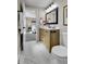 Stylish bathroom with a wood vanity, white marble floor, and neutral walls at 10431 Holland St, Broomfield, CO 80021
