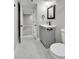 A modern bathroom showcases gray vanity, black hardware, and marble-look tile floors at 10431 Holland St, Broomfield, CO 80021
