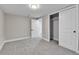 This carpeted bedroom features a closet with sliding doors, trim, and an open entry door at 10431 Holland St, Broomfield, CO 80021