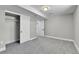 This carpeted bedroom features a closet with sliding doors, trim, and an open entry door at 10431 Holland St, Broomfield, CO 80021