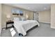 Bright main bedroom with carpet, a side table, and a window showing the outside at 10431 Holland St, Broomfield, CO 80021