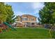 Large backyard with a lush lawn, patio area, and play structure at 425 Peabody St, Castle Rock, CO 80104