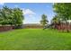 Large backyard with grass, trees, fence and play structure with slide and swing set at 425 Peabody St, Castle Rock, CO 80104