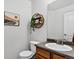 Cozy powder room with a vanity, decorative mirror, and floating shelves with plants on a clean white wall at 425 Peabody St, Castle Rock, CO 80104