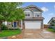 Two-story home featuring a two-car garage, blue front door, and manicured landscaping at 425 Peabody St, Castle Rock, CO 80104