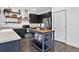 Modern kitchen featuring dark cabinetry, stainless steel appliances, and a butcher block-topped island with shelving at 425 Peabody St, Castle Rock, CO 80104