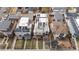 A close aerial view of modern, multi-story homes with rooftop decks and solar panels, surrounded by green lawns at 2723 Grove St, Denver, CO 80211