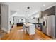 Modern kitchen with stainless steel appliances, white island, and hardwood floors at 2723 Grove St, Denver, CO 80211