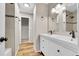 Updated bathroom with a double sink vanity, tile backsplash, and wood-look flooring at 3890 S Atchison Way # B, Aurora, CO 80014