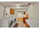 Functional laundry room with modern washer and dryer, cabinet storage, and concrete flooring at 3890 S Atchison Way # B, Aurora, CO 80014