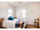Bright bedroom featuring a bed with colorful blanket, wood floors, and natural light from the window at 4452 Stuart St, Denver, CO 80212