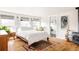 Bright bedroom featuring a bed, wood floors, bedside tables, plants, and three large windows for ample natural light at 4452 Stuart St, Denver, CO 80212