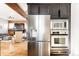 Spacious kitchen with stainless steel appliances, dark wood cabinets, and open living area at 4452 Stuart St, Denver, CO 80212