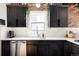 Well-lit kitchen featuring dark cabinetry, stainless steel appliances, and quartz countertops at 4452 Stuart St, Denver, CO 80212