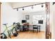 Home office space featuring hardwood floors, track lighting, a large desk and a bright green bicycle at 4452 Stuart St, Denver, CO 80212