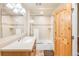 Bright bathroom with a shower over tub, large mirror and a blonde wood door at 105 S High St # A, Breckenridge, CO 80424