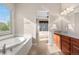 Bright bathroom featuring a soaking tub and double vanity with granite countertops at 2600 Reserve Ct, Erie, CO 80516