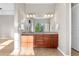 Bright bathroom featuring dual sinks, wood cabinets, and tile flooring at 2600 Reserve Ct, Erie, CO 80516