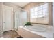 Ensuite bathroom featuring a soaking tub, glass shower, and a window with natural light at 2600 Reserve Ct, Erie, CO 80516