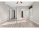 Bright bedroom with hardwood floors, a ceiling fan, and access to the bathroom and closet at 2600 Reserve Ct, Erie, CO 80516
