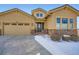 Charming tan house with well-kept landscaping, stone accents, and a concrete driveway with snow at 2600 Reserve Ct, Erie, CO 80516