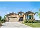 Beautifully landscaped tan home featuring a two-car garage, stone accents, and a well-maintained lawn at 2600 Reserve Ct, Erie, CO 80516