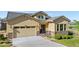 Inviting tan home with a two-car garage, stone accents, and mature landscaping, offering great curb appeal at 2600 Reserve Ct, Erie, CO 80516