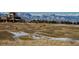 Picturesque golf course view with clubhouse and snow-capped mountains in the background at 2600 Reserve Ct, Erie, CO 80516