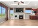 Bright living room featuring a stone fireplace, large windows with views, and wood-look flooring at 2600 Reserve Ct, Erie, CO 80516