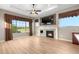 Bright living room with a stone fireplace, large windows with views, and wood-look flooring at 2600 Reserve Ct, Erie, CO 80516