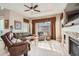 Inviting living room with fireplace, ceiling fan, hardwood floors, and bright natural light at 2600 Reserve Ct, Erie, CO 80516