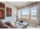 Cozy living room with a leather sofa, decorative art, and natural light from the windows at 2600 Reserve Ct, Erie, CO 80516