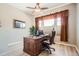 Inviting home office with dark wood desk, ceiling fan, and large window providing plenty of natural light at 2600 Reserve Ct, Erie, CO 80516