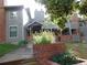 Exterior view of a home featuring gray siding, brick accents, a covered entrance, and landscaping at 1405 Broadway St # 302, Boulder, CO 80302