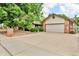 Charming home boasts a spacious driveway leading to an attached two-car garage, framed by lush landscaping at 1665 W 113Th Ave, Denver, CO 80234