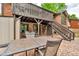 Backyard patio features exposed brick and wooden stair access to a deck at 1665 W 113Th Ave, Denver, CO 80234