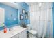Bright bathroom with blue walls, a white vanity, and a shower with a white curtain at 2562 E 90Th Pl, Thornton, CO 80229