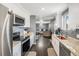Well-lit kitchen featuring white cabinets, granite countertops, and stainless steel appliances at 2562 E 90Th Pl, Thornton, CO 80229
