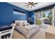 Bright bedroom features blue accent wall, ceiling fan, and private access to the balcony at 267 S Clermont St, Denver, CO 80246