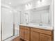 Bathroom with a double sink vanity, a shower with a glass door, and tile flooring at 9283 Biscay St, Commerce City, CO 80022