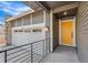 Home exterior with a yellow front door, stone accents, and two-car garage at 9283 Biscay St, Commerce City, CO 80022